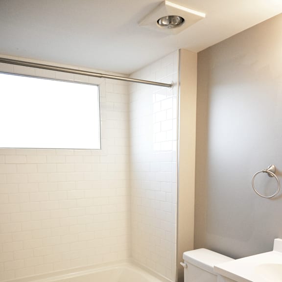 a white toilet in a bathroom with a black and white floor.