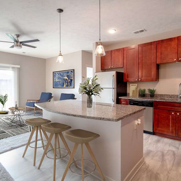 a kitchen with a white island and wooden bar stools.