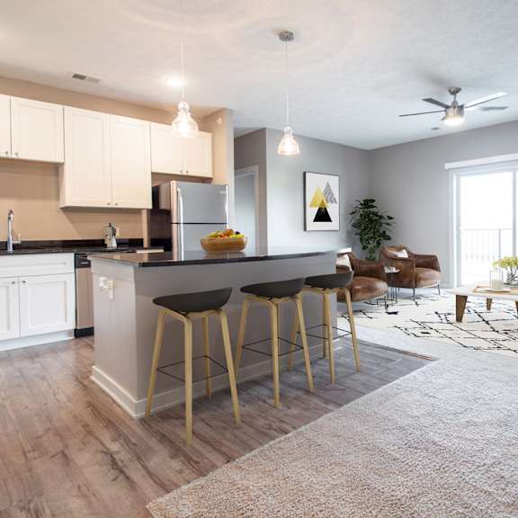 a kitchen with a bar and stools in front of it.