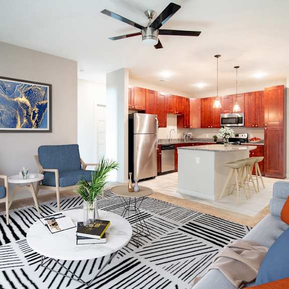 a living room with a black and white striped rug, a blue couch, and a painting on the wall.