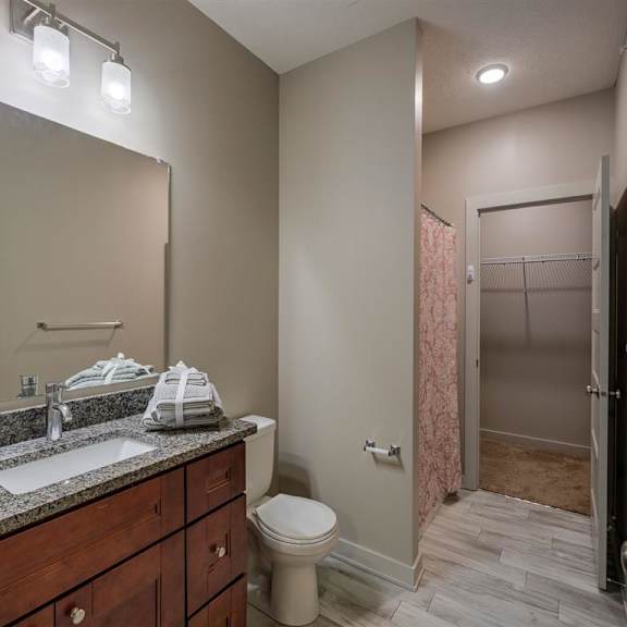 a bathroom with a toilet, sink, and shower.