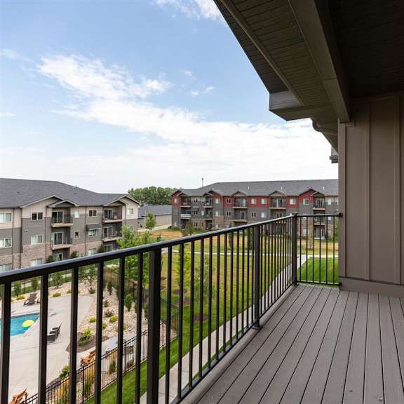 a balcony with a black railing and a view of apartment buildings.
