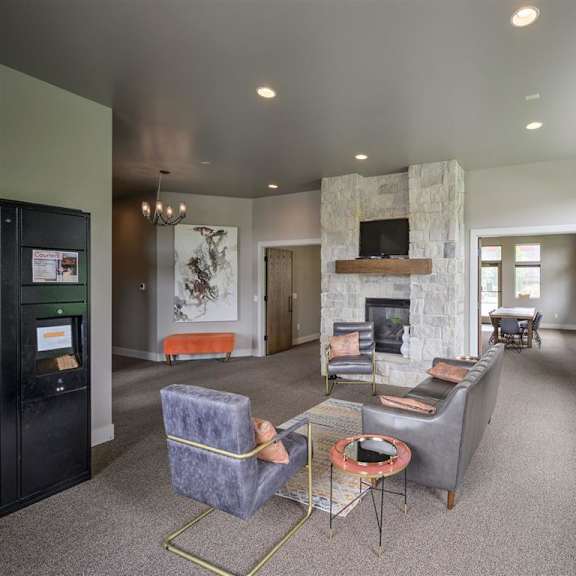 a living room with a stone fireplace and grey couches.