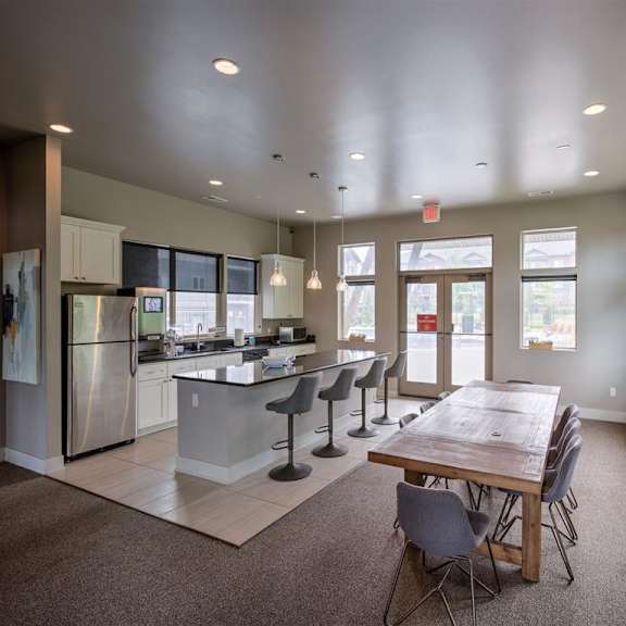 a kitchen with a table and chairs in the foreground and a refrigerator in the background.