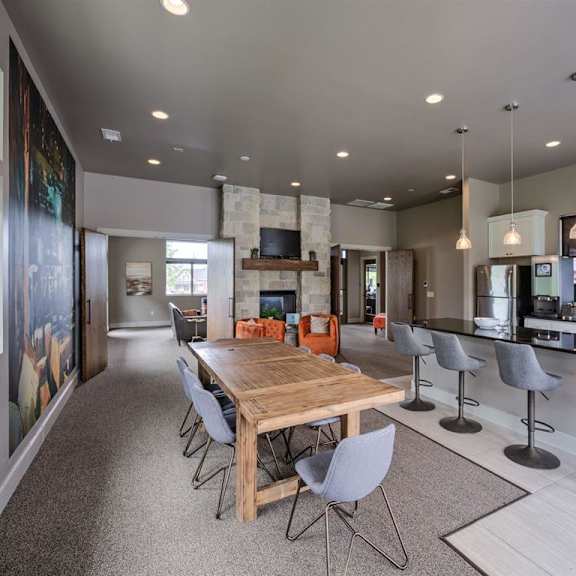 a modern dining room with a wooden table and grey chairs.