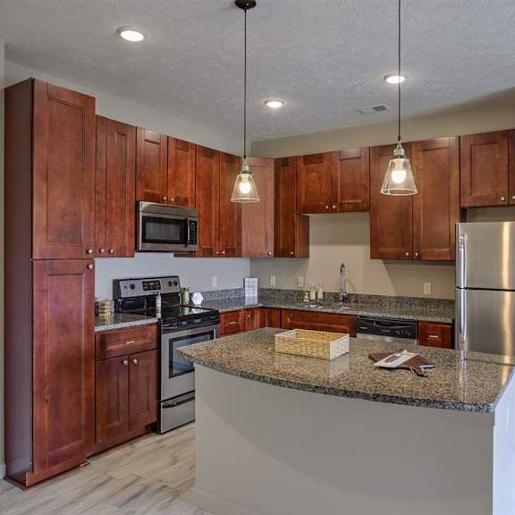 a kitchen with wooden cabinets and a granite countertop.