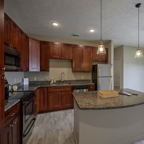 a kitchen with wooden cabinets and granite countertops.