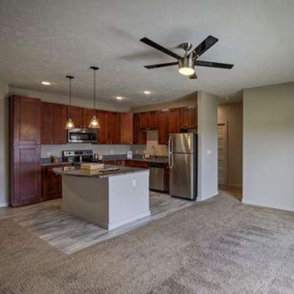 a spacious kitchen with a refrigerator, microwave, and oven.