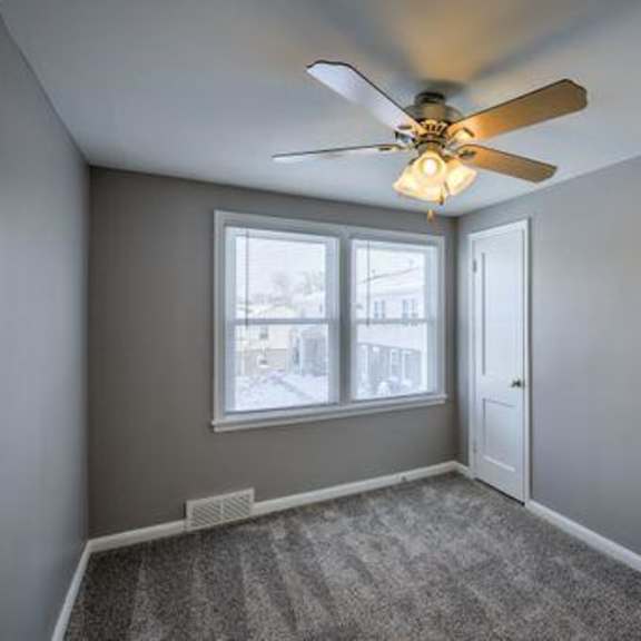 a room with a ceiling fan and a carpeted floor.