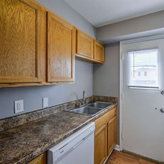 a kitchen with wooden cabinets and a granite countertop.