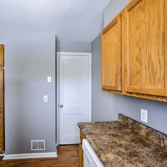 a kitchen with a granite countertop and wooden cabinets.