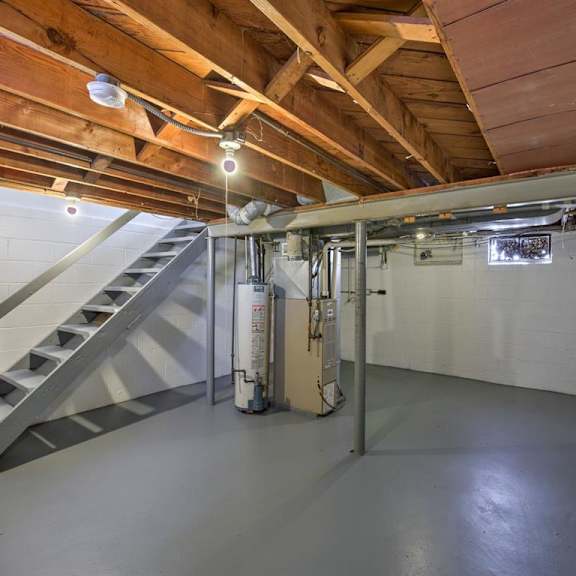 a spacious attic room with a staircase and a fire extinguisher.