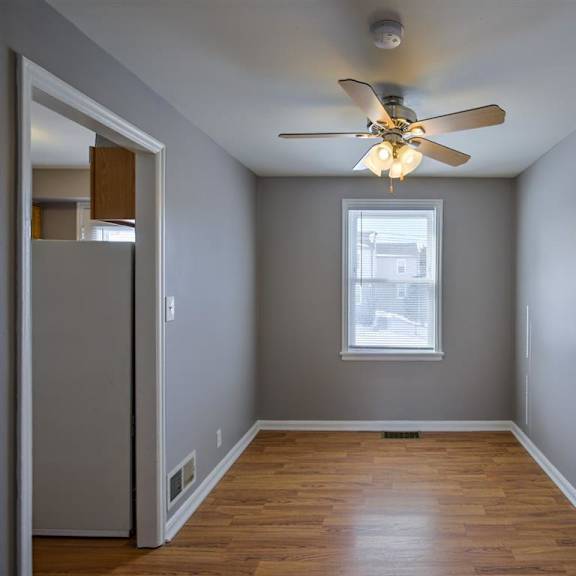 a room with a ceiling fan and a window.