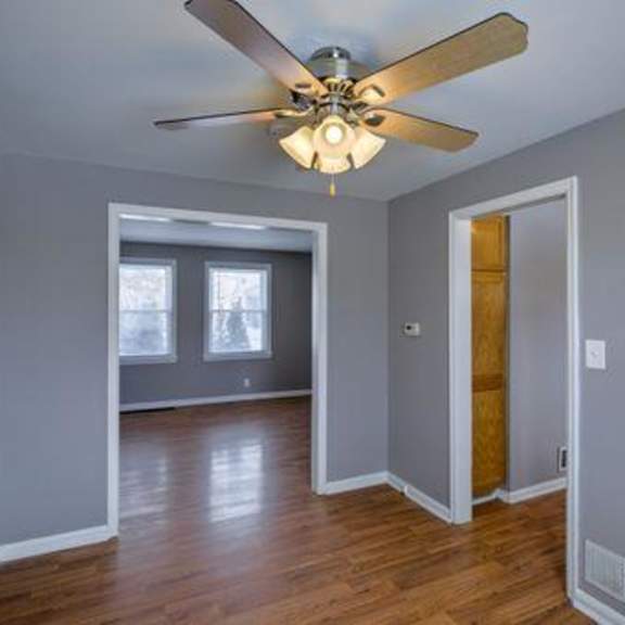 a room with a ceiling fan and a window.
