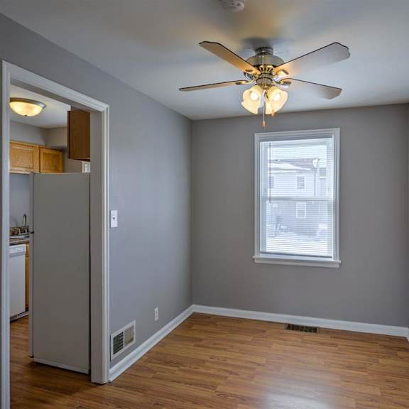 a room with a ceiling fan and a window.