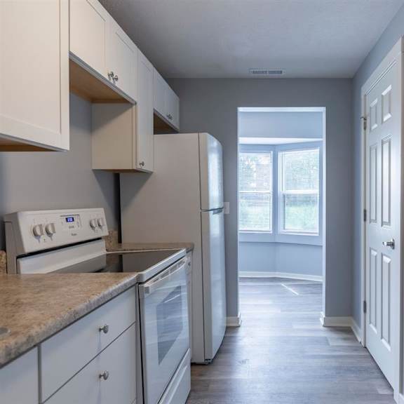 a kitchen with white cabinets and appliances.
