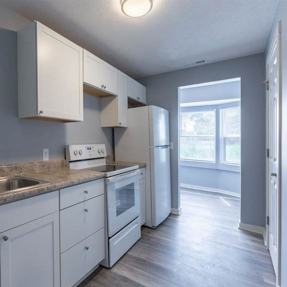 a kitchen with white cabinets and appliances.