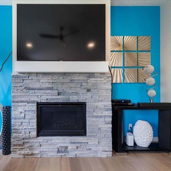 a modern living room with a fireplace and a tv above it.