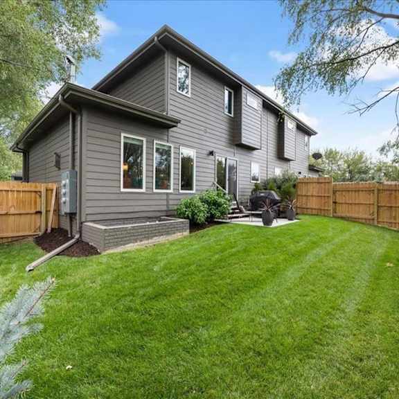 a house with a grey exterior and a green lawn.