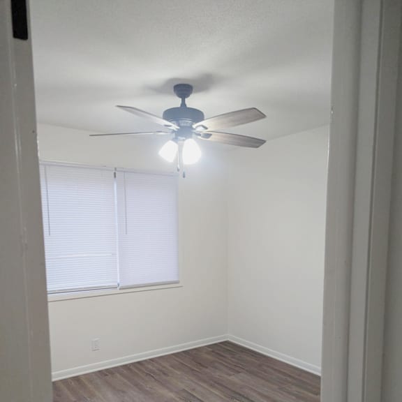 bedroom with wood style flooring ceiling fan and window at northbrook apartments