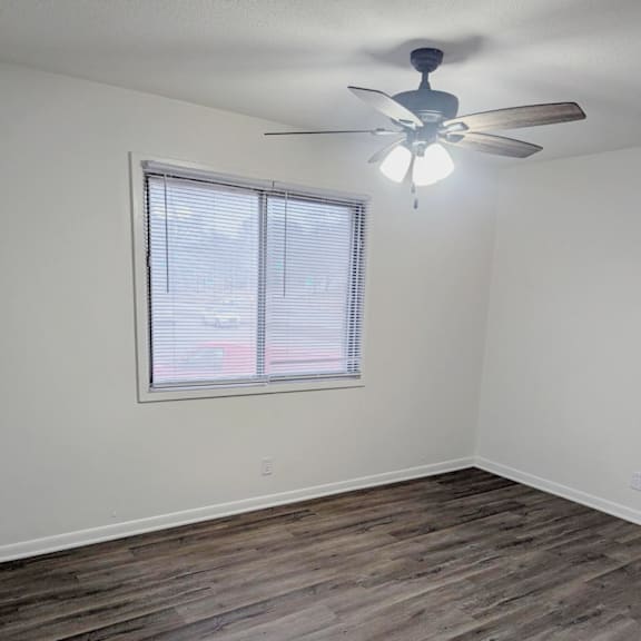 bedroom with wood style flooring ceiling fan and window at northbrook apartments
