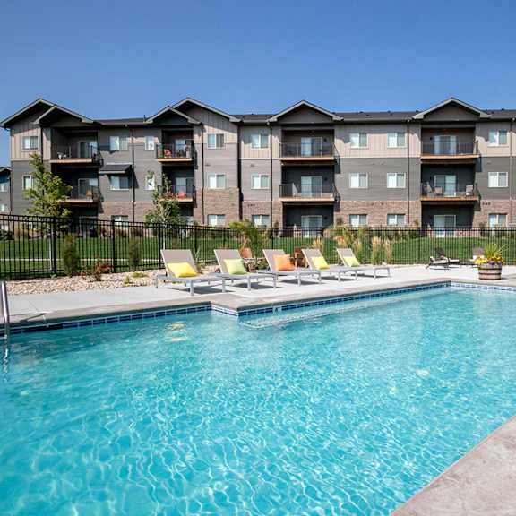 a large swimming pool in front of apartment buildings.