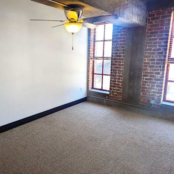 a room with a ceiling fan and a window.