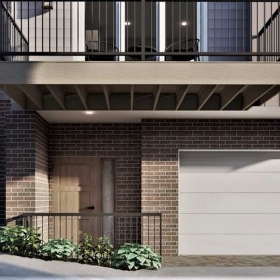 a modern two-story building with a balcony and garage doors.