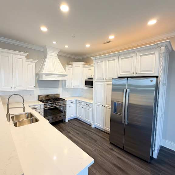 a kitchen with white cabinets and a stainless steel refrigerator.