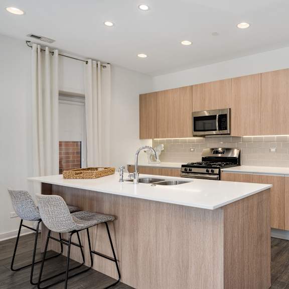a modern kitchen with a white countertop and stainless steel appliances.