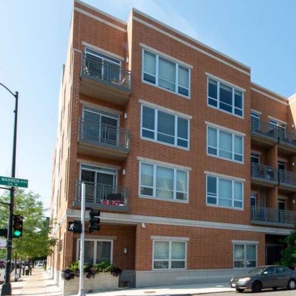 a large brick building with cars parked in front of it  at tripp 4321, chicago, 60641