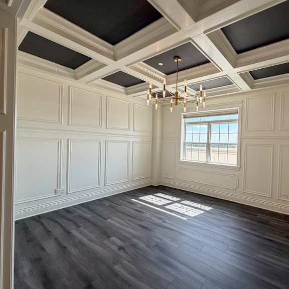 a room with a window and a chandelier.