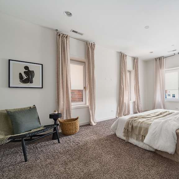 a bedroom with a large bed and a chair.