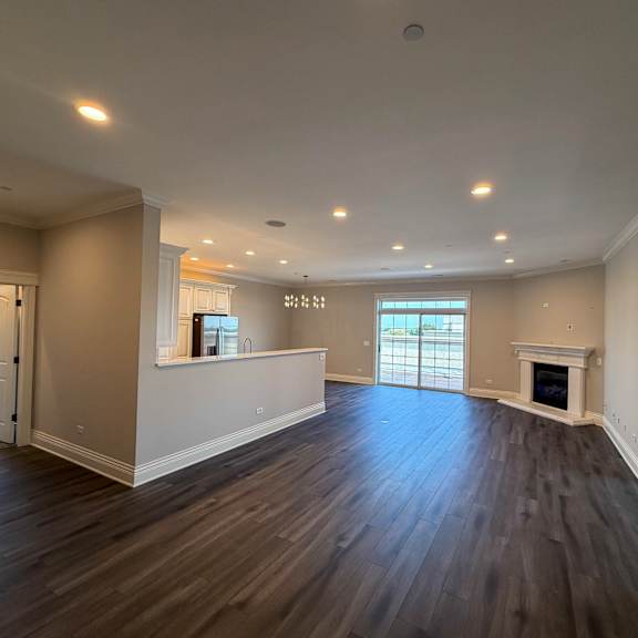 a spacious living room with hardwood floors and a fireplace.