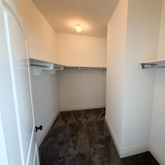 a small, empty room with a grey carpet and white walls.