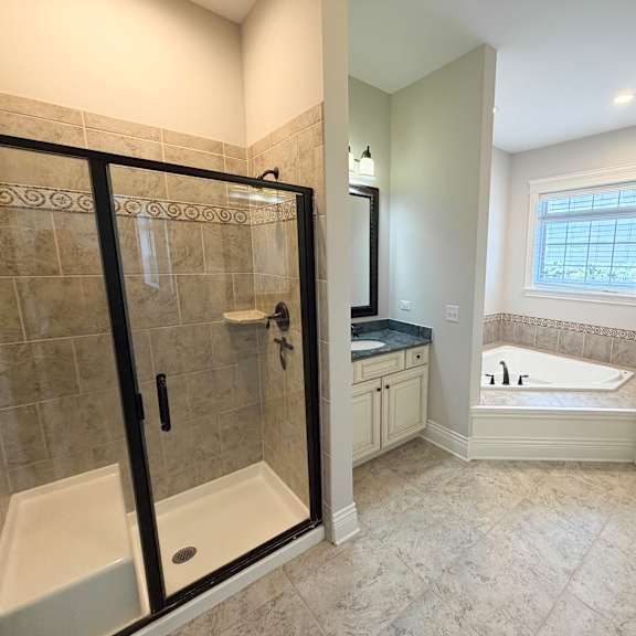 a bathroom with a walk-in shower and a bathtub.