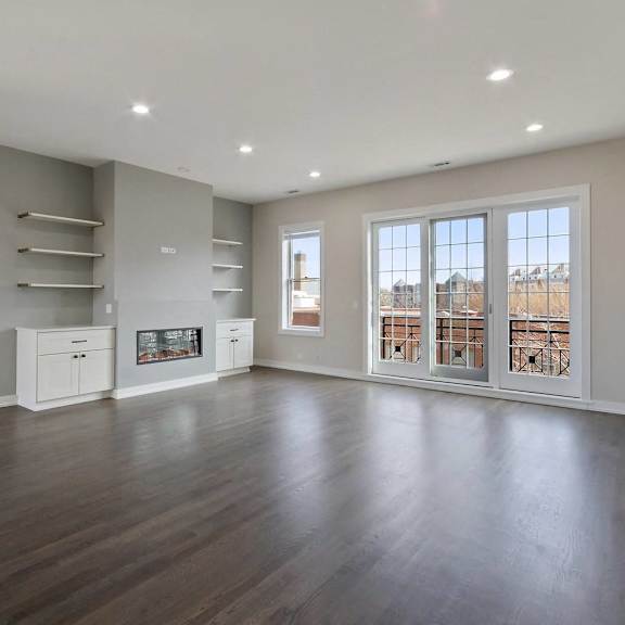 an empty living room with a fireplace and a large window