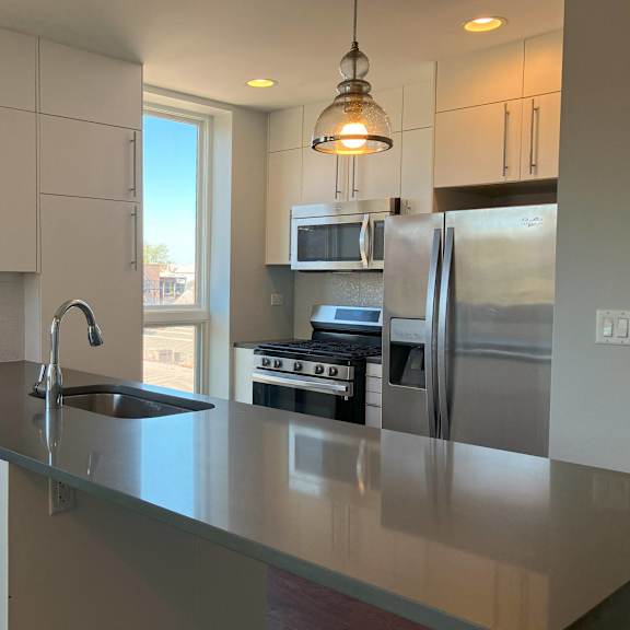 a kitchen with a large island and stainless steel appliances