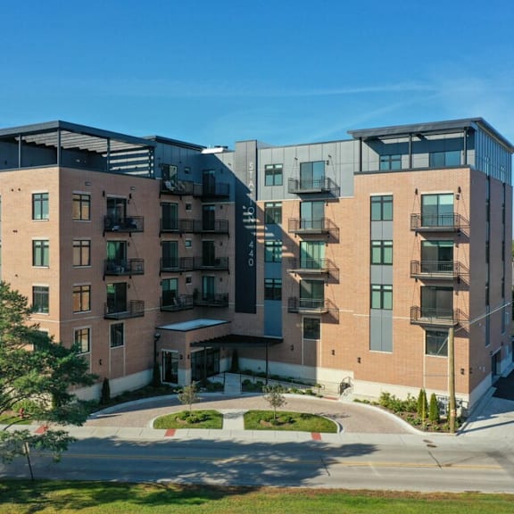 a brick apartment building with balconies and a sidewalk