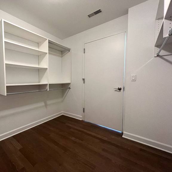 a bedroom with white walls and a closet with shelves