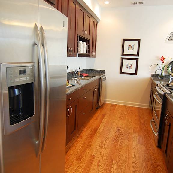 a kitchen with stainless steel appliances and wooden floors