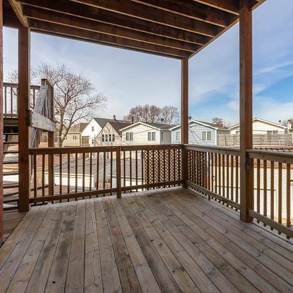 the deck of a home with a view of a yard and houses