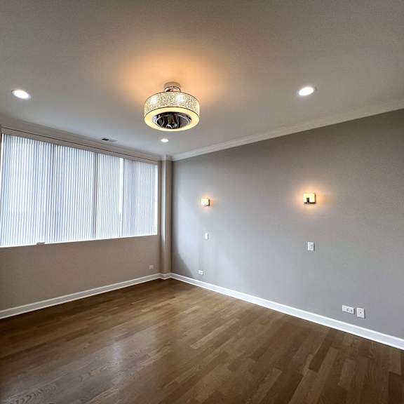 a living room with wood flooring and a large window
