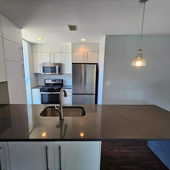 an empty kitchen with a counter top and a sink