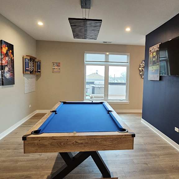 a game room with a pool table and a tv