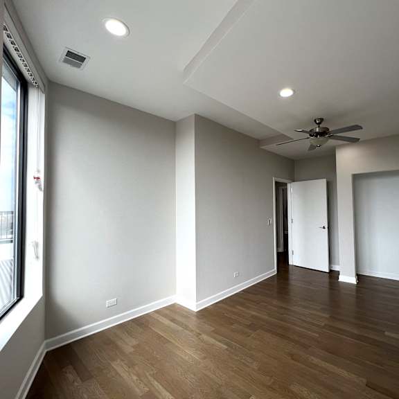 a living room with white walls and a ceiling fan