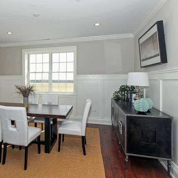 a dining room with a wooden table and white chairs