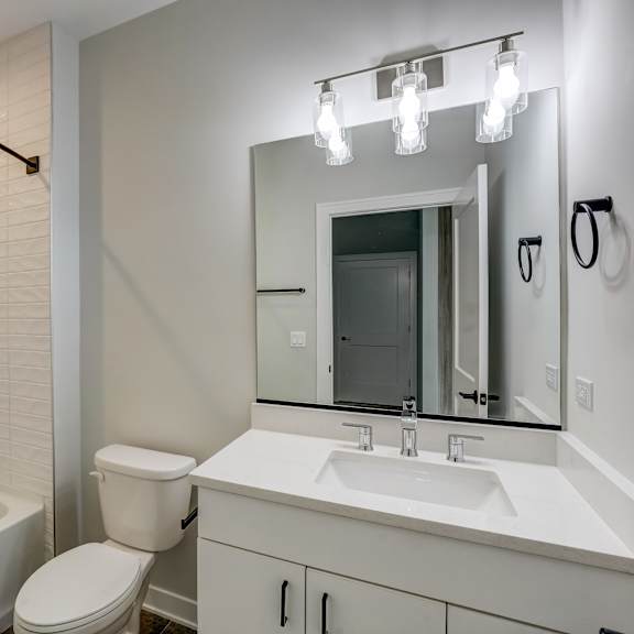 a bathroom with a mirror and a toilet and a tub