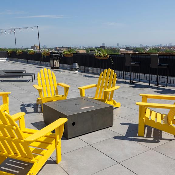 a group of yellow chairs around a fire pit on top of a roof at talman 1554, illinois