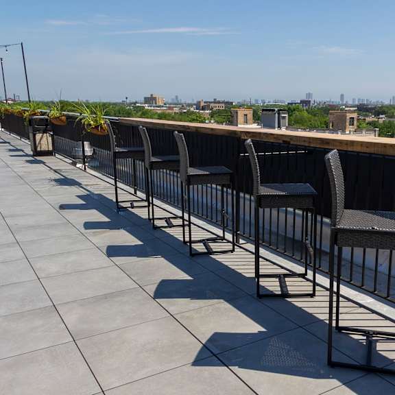 a row of chairs on a roof overlooking a city at talman 1554, chicago